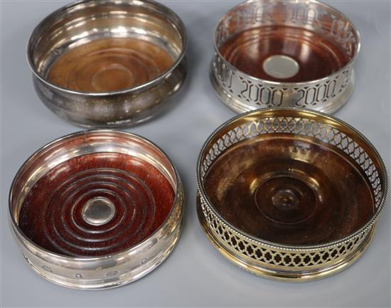 Four assorted modern silver wine coasters including one silver gilt.